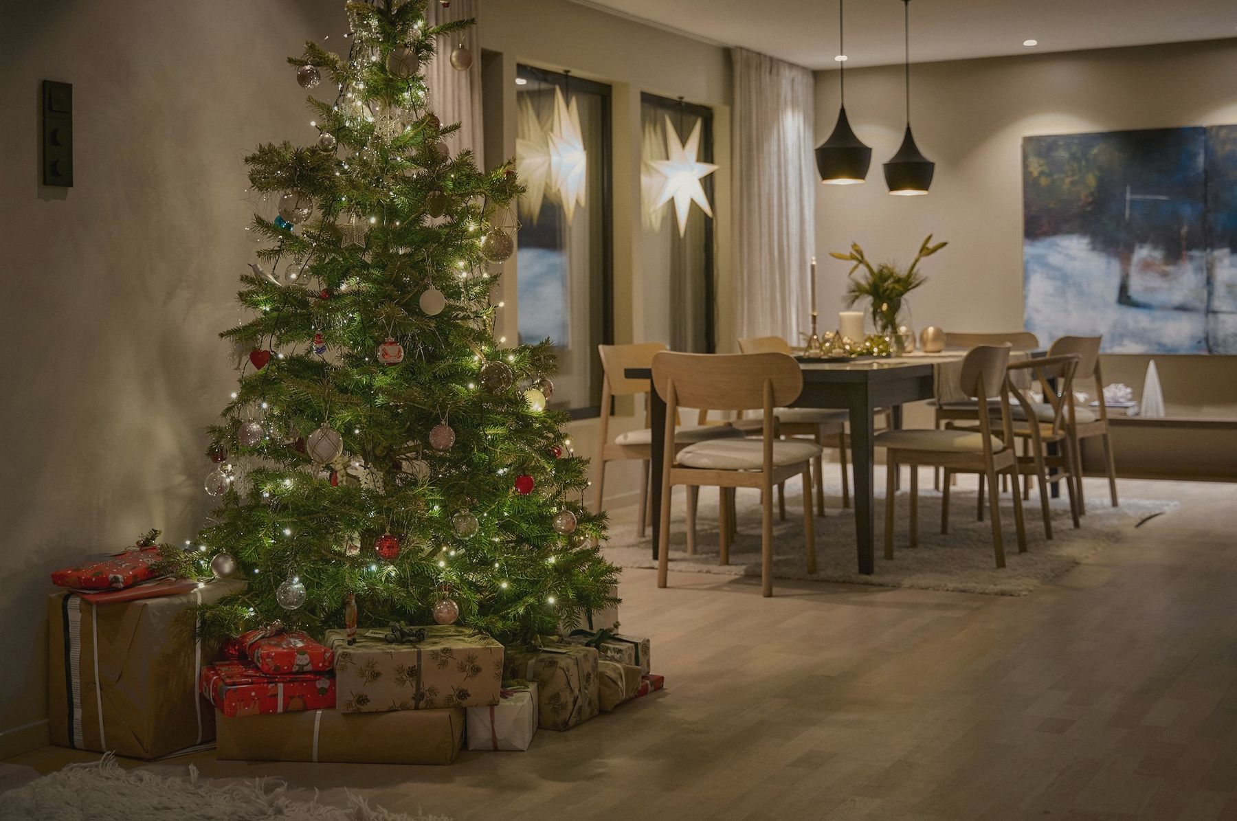 A lit Christmas tree in an open dining room