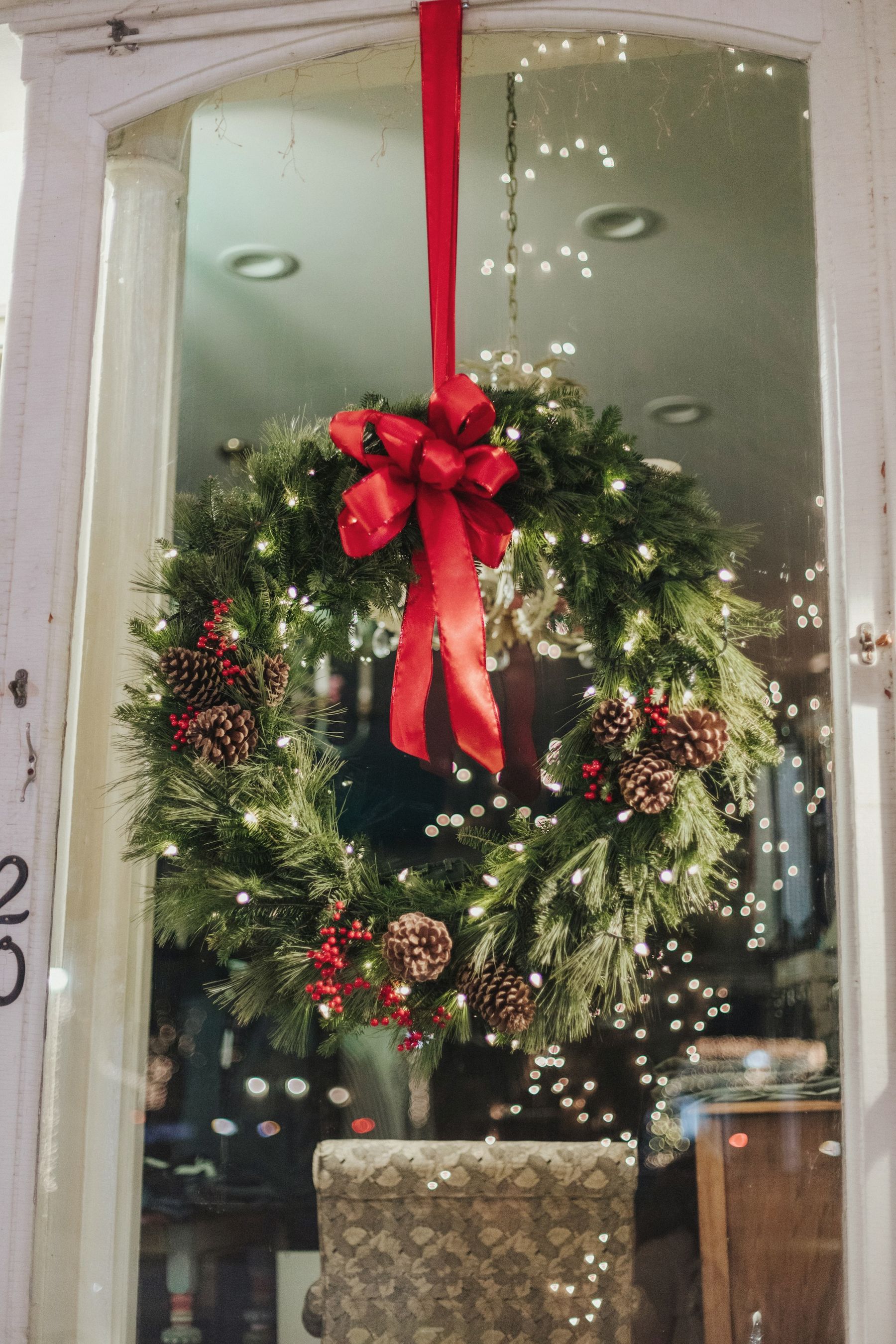 A front door wreath with a red velvet bow